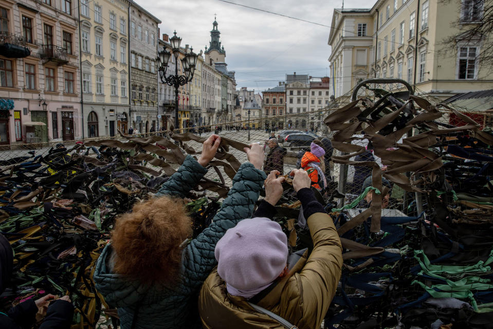 Volunteers tie pieces of fabric while making camouflage nets outside the Ivanychuk Library in Lviv on March 1.<span class="copyright">Ethan Swope—Bloomberg/Getty Images</span>
