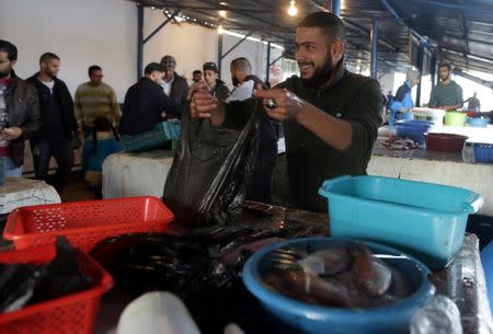 Mutassim al-Misrati, a Benghazi-local who lost his leg during a three-year war in the city, sells fish at a market in Benghazi, Libya December 27, 2017. Picture taken December 27, 2017. REUTERS/Esam Omran Al-Fetori