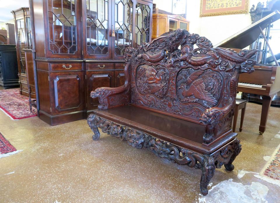 An orntate carved bench in the first floor gallery at Mill House Antiques in Long Branch Monday, February 27, 2023.  The second-generation, Long Branch-based provider of antique furnishings, lighting, jewelry, grand pianos, and rare small valuables has been in operation since 1973.