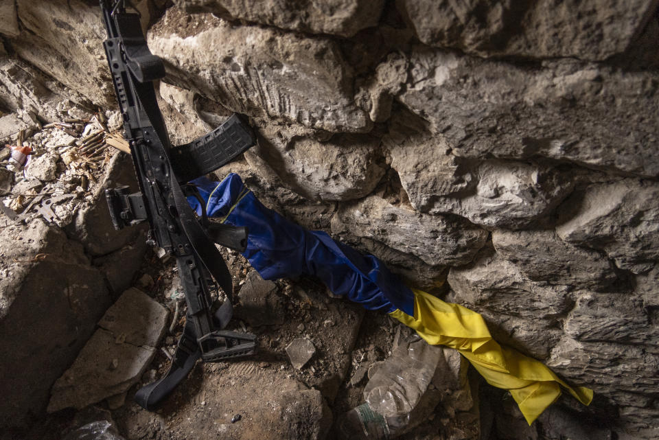 A Ukrainian flag is seen next to a rifle inside a bunker at a frontline position in Andriivka, Donetsk region, Ukraine, Saturday, Sept. 16, 2023. A Ukrainian brigade's two-month battle to fight its way through a charred forest shows the challenges of the country's counteroffensive in the east and south. (AP Photo/Mstyslav Chernov)