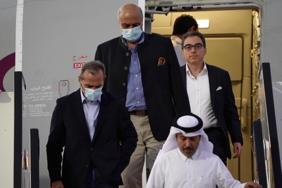De izquierda a derecha, Emad Sharghi, Morad Tahbaz y Siamak Namazi, que estuvieron presos en Irán, desembarcan de un avión de Qatar Airways que los llevó de Teherán a Doha, Qatar, el 18 de septiembre de 2023. (AP Foto/Lujain Jo)