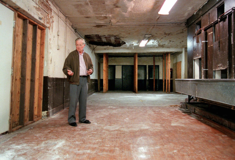 FILE - In this June 5, 1998 file photo, Associated Press reporter Bob Thomas stands on the spot where Sen. Robert F. Kennedy lay on the floor after he was shot in an Ambassador Hotel pantry exactly 30 years prior in Los Angeles' Mid-Wilshire district. From the press room next door Thomas heard the gunshots, then yells and screams from the pantry, and rushed in to find the dying Kennedy lying on the floor. Thomas died of age-related illnesses Friday, March 14, 2014 at his Encino, Calif., home, his daughter Janet Thomas said. He was 92. (AP Photo/Reed Saxon, File)