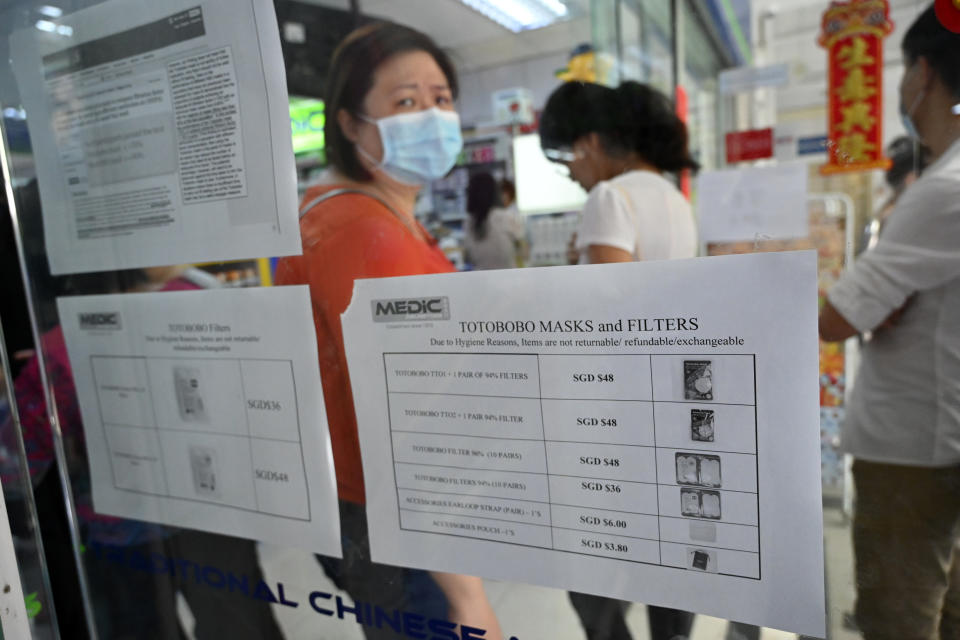 People queue to purchase protective face mask, sanitizer and thermometer at a pharmacy in Singapore on January 29, 2020. - Singapore has so far confirmed seven cases of the novel coronavirus, a virus similar to the SARS pathogen -- all of them arrivals from Wuhan. (Photo by Roslan RAHMAN / AFP) / TO GO WITH China-health-virus-tourism-hotels,SCENE by Sebastien RICCI (Photo by ROSLAN RAHMAN/AFP via Getty Images)