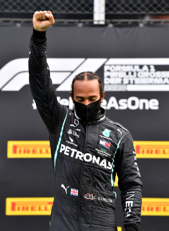 Lewis Hamilton de Mercedes lleva una mascarilla protectora mientras celebra su victoria en el podio, tras la reanudación de la F1 después del brote de la enfermedad del coronavirus (COVID-19)