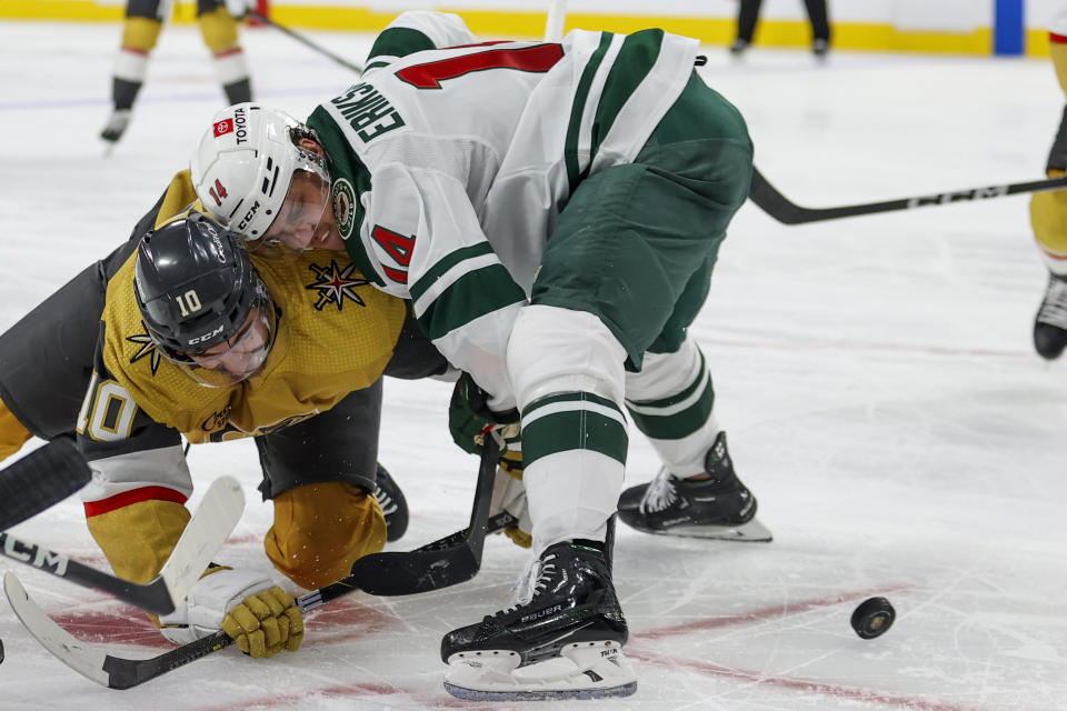 Vegas Golden Knights center Nicolas Roy (10) and Minnesota Wild center Joel Eriksson Ek (14) collide during a face-off during the second period of an NHL hockey game Monday, Feb. 12, 2024, in Las Vegas. (AP Photo/Ian Maule)