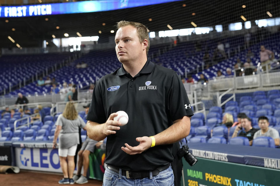 NASCAR driver Cole Custer holds a baseball before throwing a ceremonial pitch before a baseball game between the Miami Marlins and Chicago Cubs, Monday, Sept. 19, 2022, in Miami. (AP Photo/Lynne Sladky)