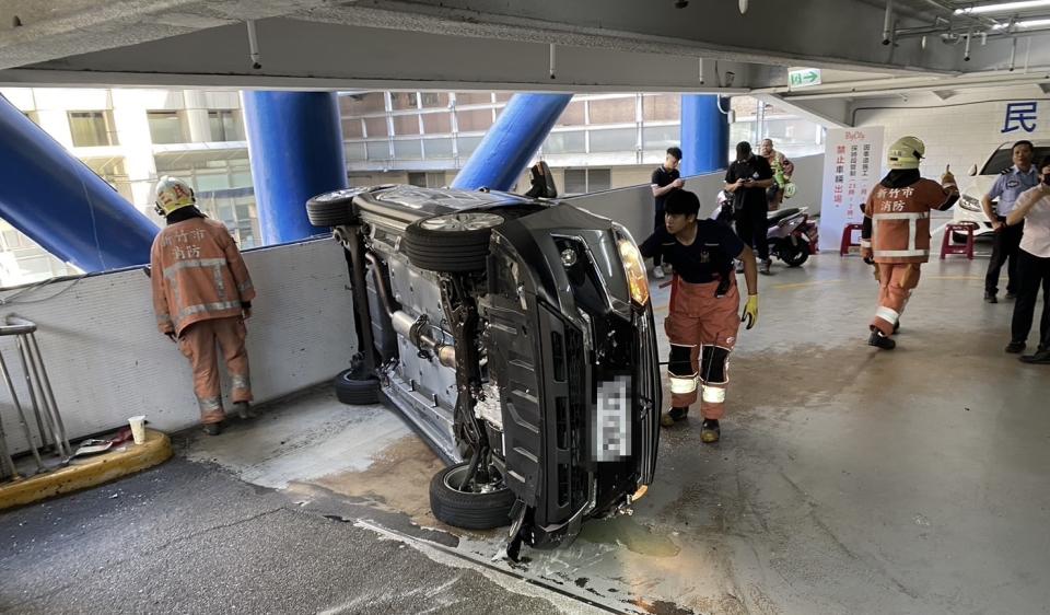 黑色轎車翻覆側躺在車道上。（圖／翻攝畫面）