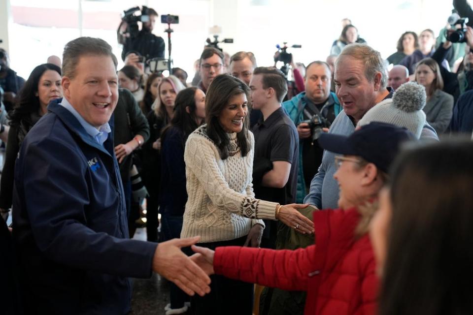 Republican presidential candidate former U.N. Ambassador Nikki Haley, second left, accompanied by New Hampshire Gov. Chris Sununu, left, meets with diners at the Beach Plum in Epping, N.H., Sunday, Jan. 21, 2024.