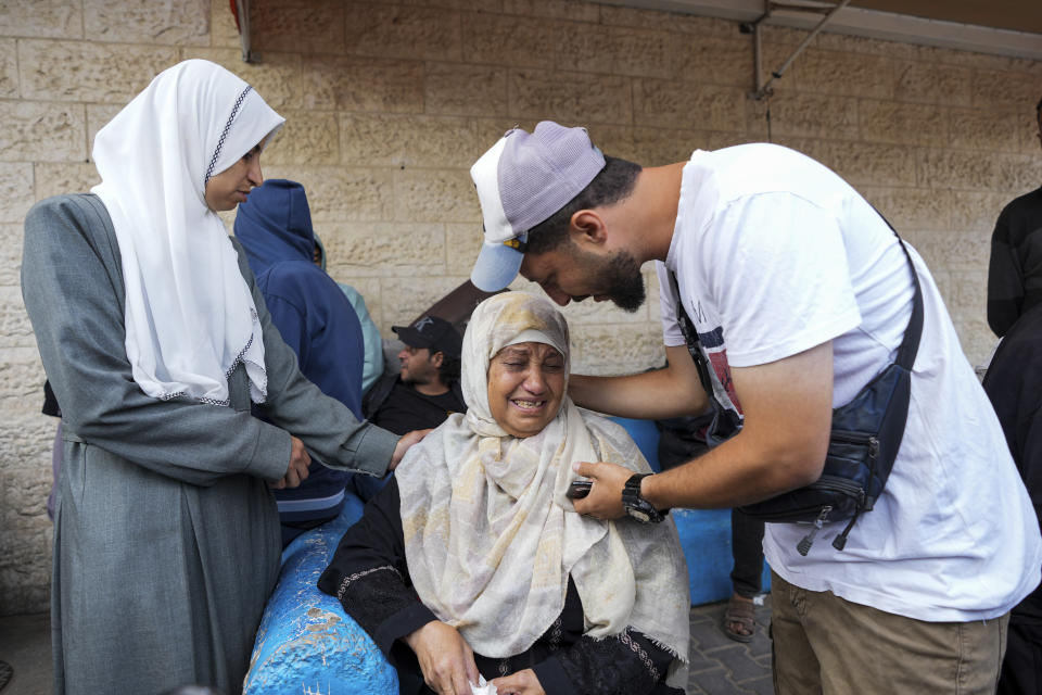 Palestinians mourn their relatives killed during Israeli airstrikes in the Gaza Strip, next to the morgue in Deir al Balah, Tuesday, May 14, 2024. (AP Photo/Abdel Kareem Hana)