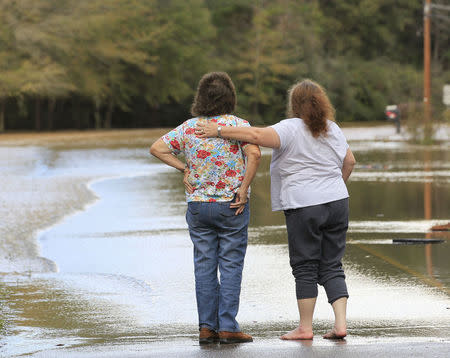 Neighbours console each other after floods waters entered their business in Elba, Alabama, December 26, 2015. REUTERS/Marvin Gentry