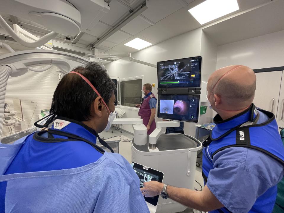 Prof Shah and a colleague looking at the route generated by the mapping software which shows how the catheter should be guided through lungs (Royal Brompton Hospital/PA)