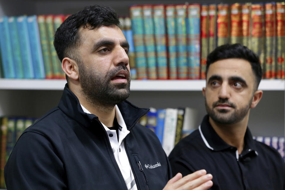 Brothers Samiullah Safi, left, and Abdul Wasi Safi speak during an interview after Friday prayers at the Al-Noor Society Mosque in Houston, on April 7, 2023. Abdul, who had suffered injuries while assisting the U.S. military in Afghanistan during the war, has recently arrived in Houston after being detained for months, but has no documentation allowing him to begin a normal life with his brother. (AP Photo/Michael Wyke)