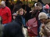 Shoppers walk in wet and windy weather on Oxford Street in central London December 23, 2013. REUTERS/Olivia Harris