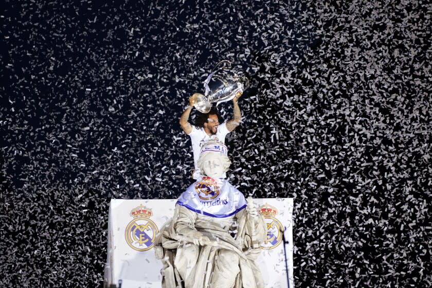 ARCHIVO - Marcelo del Real Madrid alza el trofeo de la Liga de Campeones, el 29 de mayo de 2022 en la Plaza de Cibeles. (AP Foto/Andrea Comas)