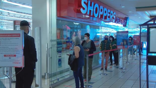 People wait in line to receive an AstraZeneca-Oxford vaccine at a Shoppers Drug Mart in Vancouver on March 31.