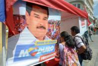 Venezuela's opposition has been hoping to capitalize on the unpopularity of Nicolas Maduro, pictured in poster, to win control of the National Assembly in the December 6 polls