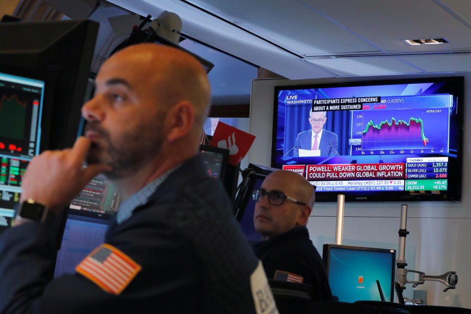 Traders work on the floor of the New York Stock Exchange as Federal Reserve Chairman Jerome Powell holds a news conference on the television behind them in New York, U.S., June 19, 2019.  REUTERS/Lucas Jackson