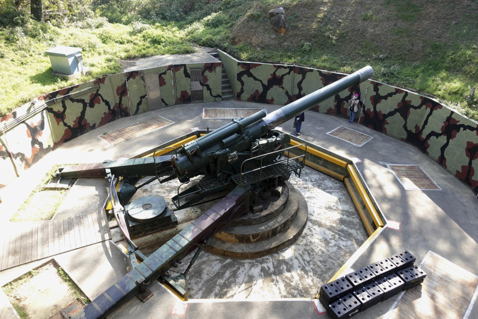 A couple takes photos near an antiquated 240mm howitzer at the observation deck at a base turned into a museum on Nangan Island, part of Matsu Islands on Monday, March 6, 2023. Just 10km away from mainland China at its closest, Matsu became a fortress and frontline of defense for the Nationalists who had retreated to Taiwan in 1949 after losing to the Communist Party in a civil war. (AP Photo/Johnson Lai)