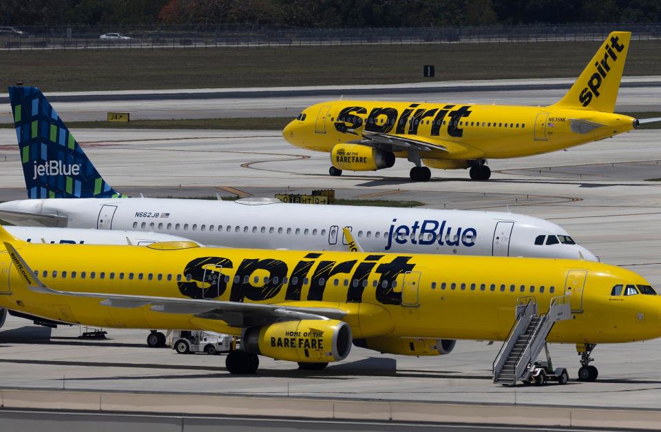 A JetBlue Airlines plane is seen near Spirit Airlines planes at the Fort Lauderdale-Hollywood International Airport on May 16, 2022 in Fort Lauderdale, Florida.