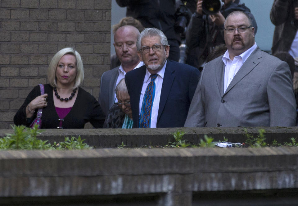 Veteran entertainer Rolf Harris, second right, arrives with his wife Alwen Hughes, third right, and daughter Bindi, left, at Southwark Crown Court in London, Tuesday, May 6, 2014. Harris is charged with nine counts of indecent assault and four counts of making indecent images of children. (AP Photo/Sang Tan)