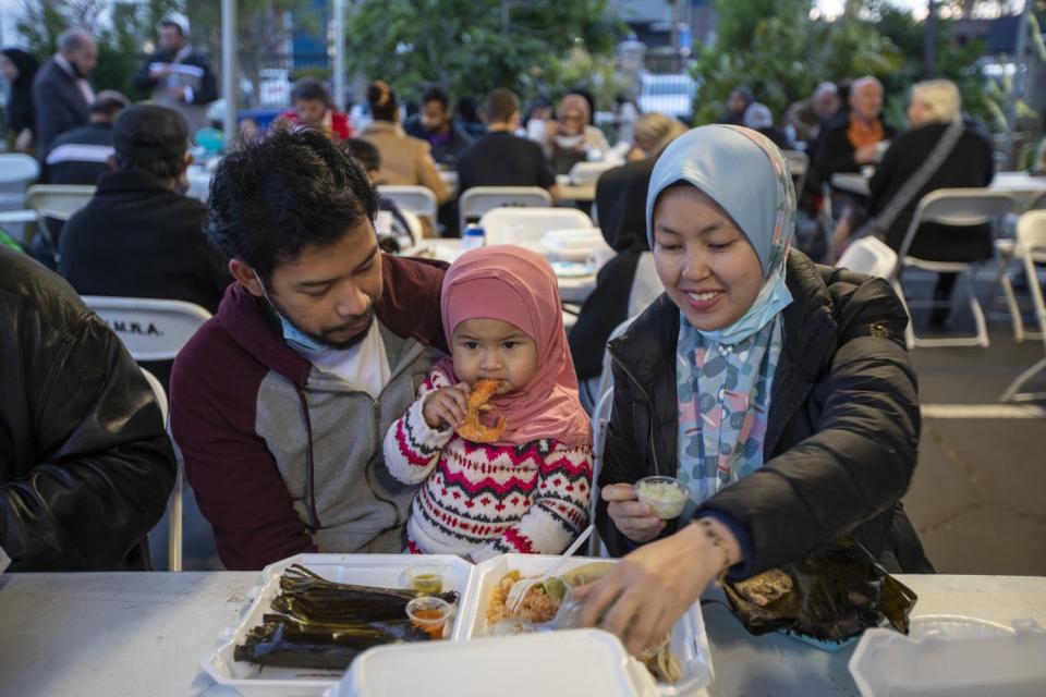 Farith El, left, Farzana Farith, 17 months, and Mariny Math enjoy dinner together