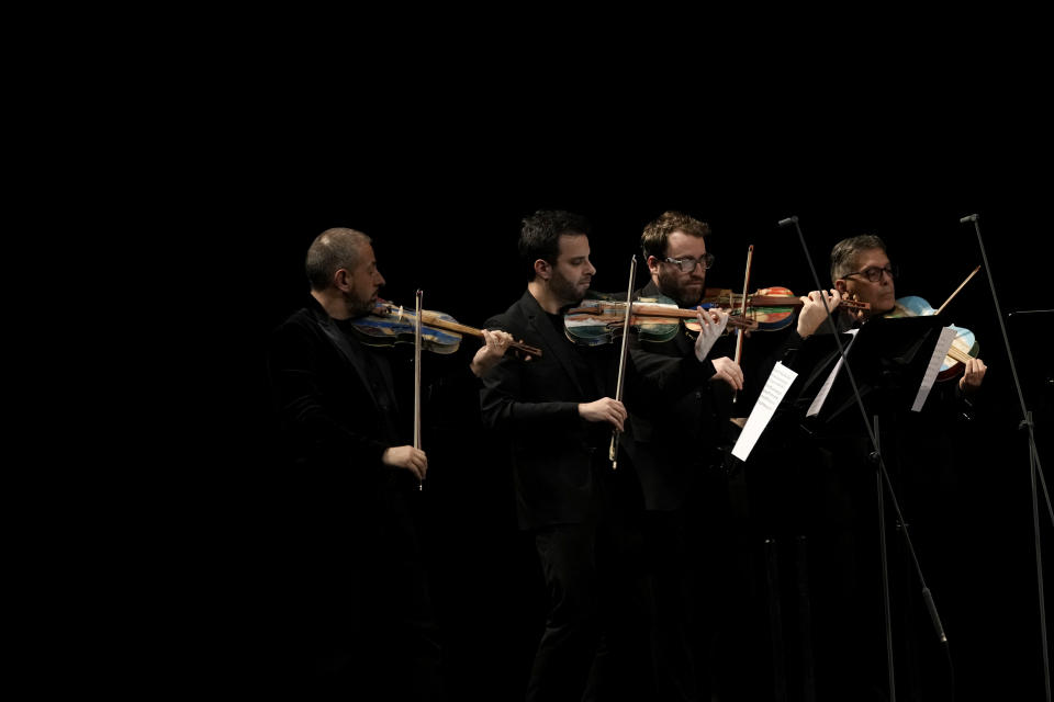 Members of the 'Sea Orchestra' play with violins made from the wood of wrecked immigrants' boats in Milan, Italy, Saturday, Feb. 10, 2024. Inmates at Milan's maximum security prison Opera took the wood of wrecked boats sailed by migrants across the Sicily Channel to craft the musical instruments that the 'Sea Orchestra' used during their debut at La Scala Opera House in Milan on Monday, Feb. 12, 2024. The violins, violas and cellos played by the Orchestra of the Sea in its debut performance Monday at Milan's famed Teatro all Scala carry with them tales of hardship. (AP Photo/Antonio Calanni)