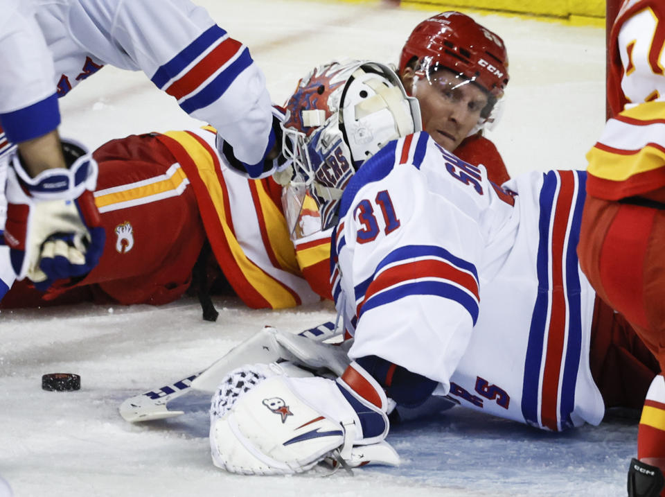 New York Rangers goalie Igor Shesterkin, right, grabs for the puck after colliding with Calgary Flames forward Blake Coleman during the second period of an NHL hockey game Tuesday, Oct. 24. 2023, in Calgary, Alberta. (Jeff McIntosh/The Canadian Press via AP)