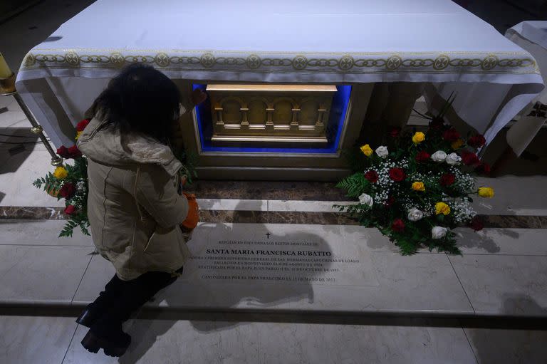 Una mujer reza junto a la urna con los restos de la Madre Francisca Rubatto en una capilla en Montevideo, mientras el Papa Francisco la canoniza en el Vaticano 