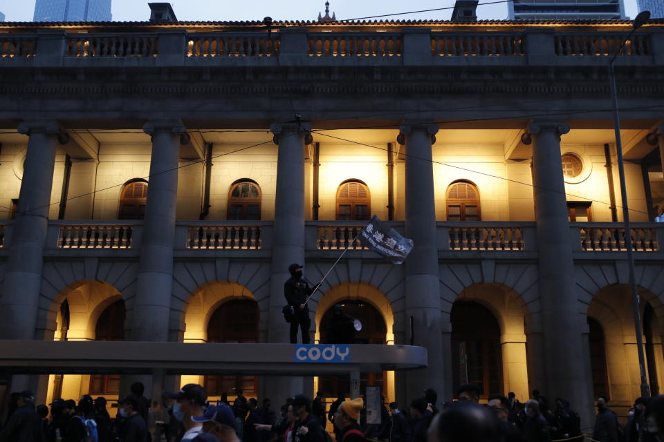 A protestor waves a flag as they leave after a massive march in Hong Kong, Wednesday, Jan. 1, 2020. A huge crowd gathered in Hong Kong Wednesday for an annual New Year’s Day protest march as the monthslong pro-democracy movement extends into 2020. (AP Photo/Lee Jin-man)