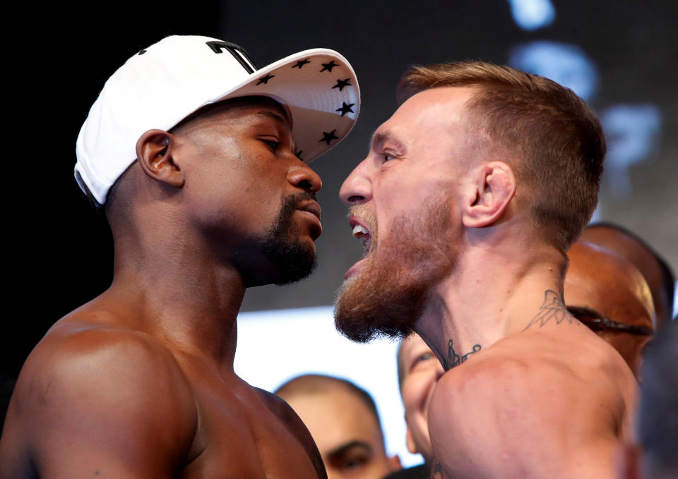 Undefeated boxer Floyd Mayweather Jr. (L) of the U.S. and UFC lightweight champion Conor McGregor of Ireland face off during their official weigh-in on Friday. (Reuters)