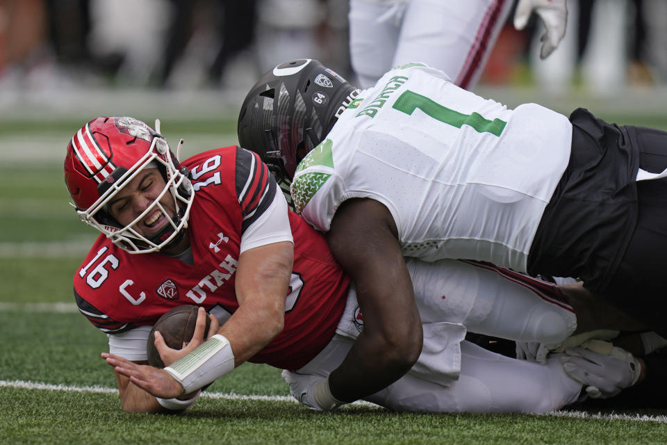 Oregon defensive end Jordan Burch (1) tackles Utah quarterback Bryson Barnes (16) during the first half of an NCAA college football game Saturday, Oct. 28, 2023, in Salt Lake City. (AP Photo/Rick Bowmer)