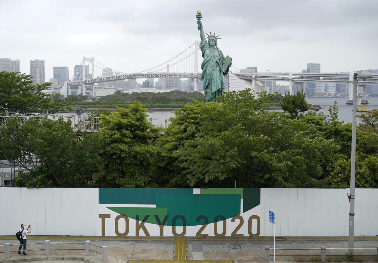 Image: An advertising board for the postponed Tokyo 2020 Olympic Games near Tokyo's Statue of Liberty replica (Naoki Ogura / Reuters)