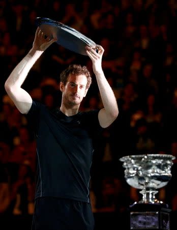 Britain's Andy Murray holds up the runner-up plate as he walks past the men's singles trophy after losing his final match against Serbia's Novak Djokovic at the Australian Open tennis tournament at Melbourne Park, Australia, January 31, 2016. REUTERS/Thomas Peter