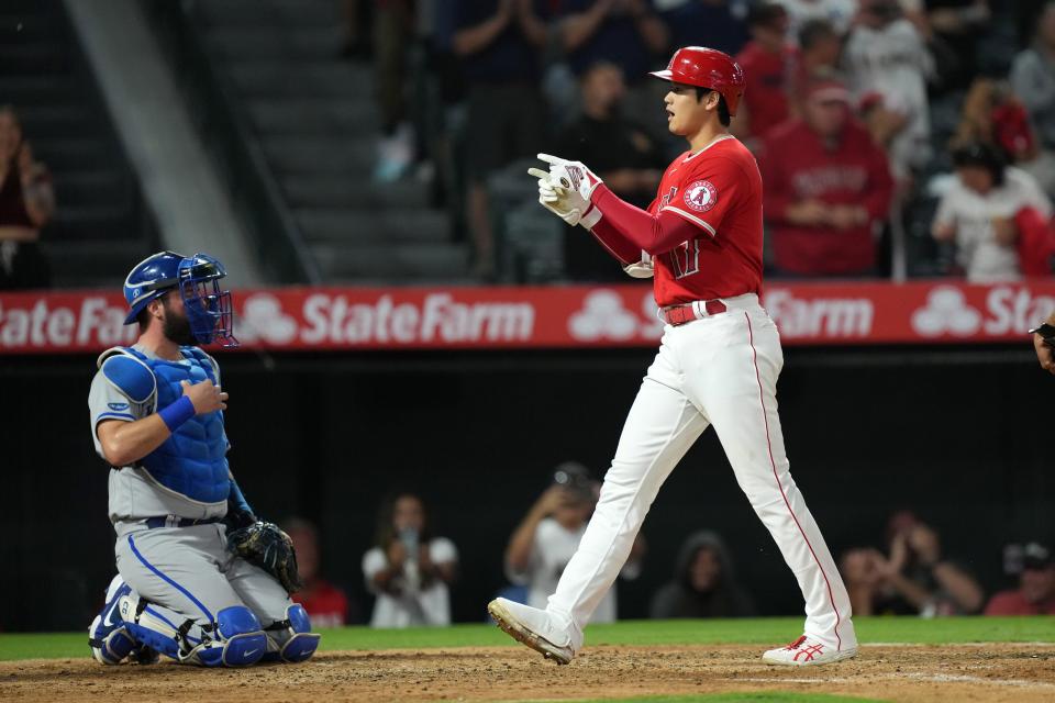 Los Angeles Angels designated hitter Shohei Ohtani (17) celebrates after hitting a three-run home run in the sixth inning as Kansas City Royals catcher Salvador Perez (13) watches at Angel Stadium.