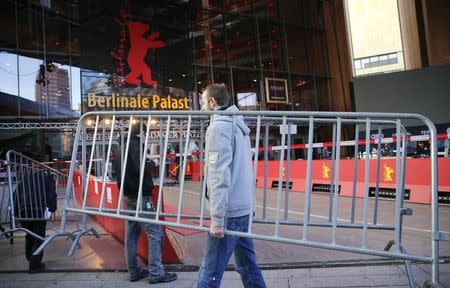 A worker carries a fence in front of the 'Berlinale Palace' during preparations for the upcoming 66th Berlinale International Film Festival in Berlin, Germany, February 10, 2016. REUTERS/Fabrizio Bensch