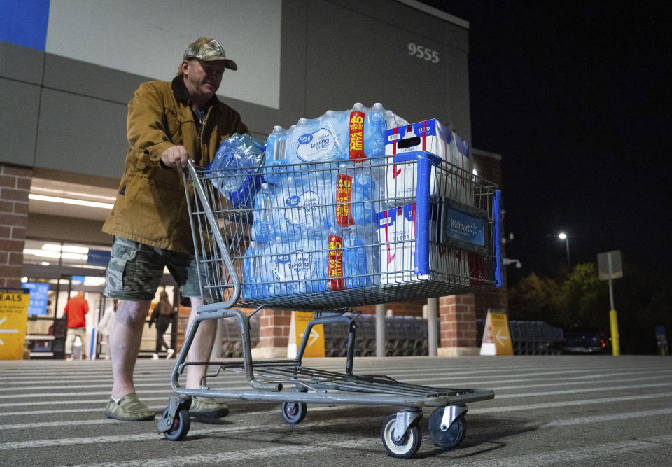 John Beezley, of Bonham, carts out several cases of water after learning that a boil water notice was issued for the entire city of Houston on Sunday, Nov. 27, 2022, at Walmart on S. Post Oak Road in Houston. Beezley just arrived in town with his wife, who is undergoing treatment starting tomorrow at M.D. Anderson Cancer Center, where they are staying in a camping trailer. They turned on the television after settling in and saw that a boil water notice had been issued. Beezley decided to go out immediately fearing that by tomorrow people would be buying up all of the available water. (Mark Mulligan/Houston Chronicle via AP)