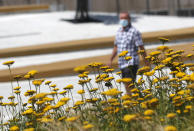 A man wearing a face mask to protect against coronavirus walks in downtown Belgrade, Serbia, Monday, July 13, 2020. Health authorities are warning that Serbian hospitals are almost full due to the latest surge. (AP Photo/Darko Vojinovic)