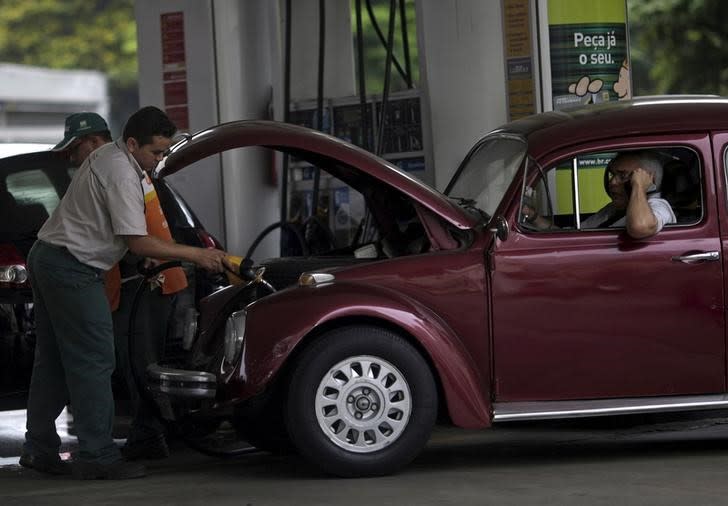 A worker fills a car at a Brazilian Oil Company Petrobras gas station in Rio de Janeiro, Brazil, September 30, 2015. REUTERS/Ricardo Moraes