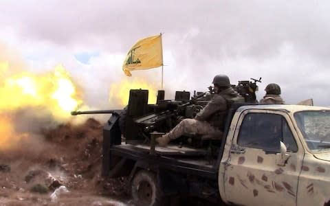 Hezbollah fighters fire on Syrian rebel positions in the Qalamun hills in 2015 - Credit: AFP PHOTO / HO / HEZBOLLAH PRESS OFFICE