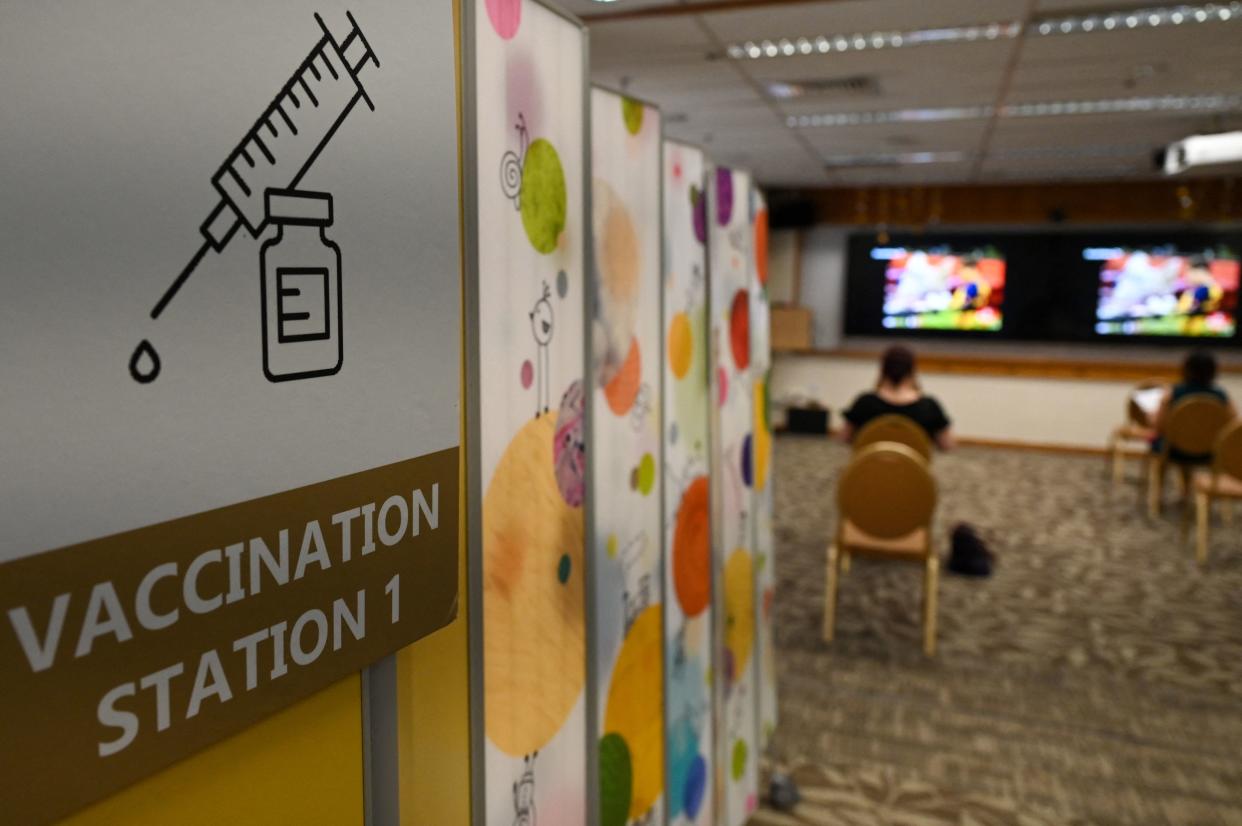 People sit and wait after receiving a dose of the Sinopharm Covid-19 coronavirus vaccine at the Mount Elizabeth hospital vaccine centre in Singapore on September 7, 2021. (Photo by Roslan Rahman / AFP) (Photo by ROSLAN RAHMAN/AFP via Getty Images)