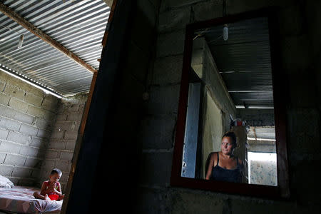 Oleydy Canizalez (R), 29, looks at her son Luis, 3, while he eats lunch, before her sterilization surgery, at their home in Charallave, Venezuela July 7, 2016. REUTERS/Carlos Garcia Rawlins