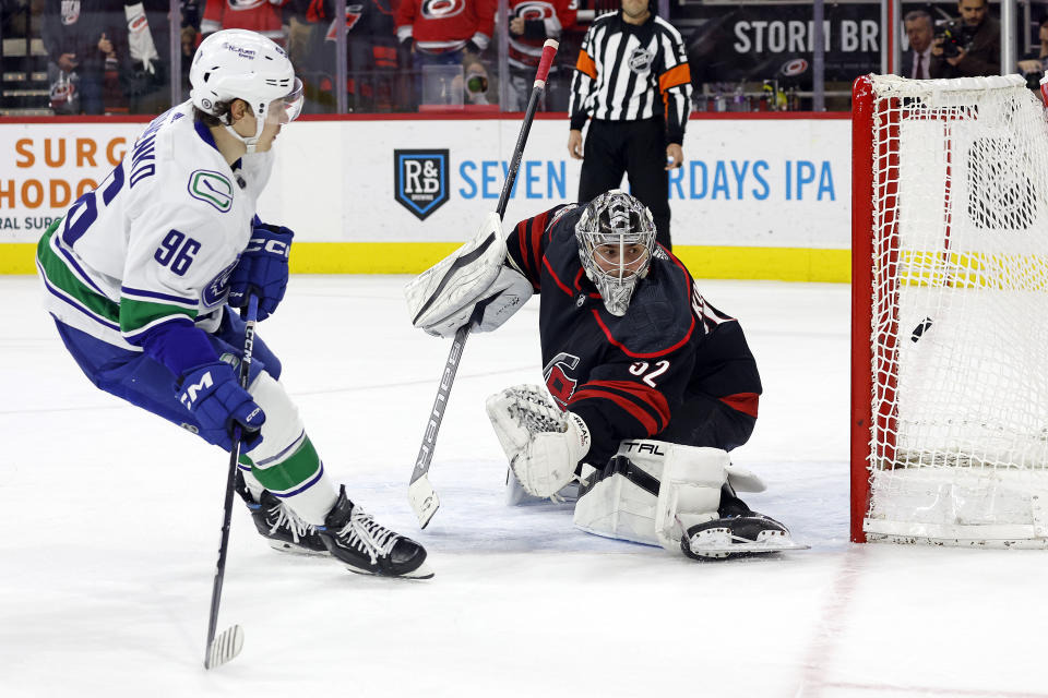 Vancouver Canucks' Andrei Kuzmenko (96) successfully shoots the puck past Carolina Hurricanes goaltender Pyotr Kochetkov (52) for a shootout goal in an NHL hockey game in Raleigh, N.C., Sunday, Jan. 15, 2023. (AP Photo/Karl B DeBlaker)