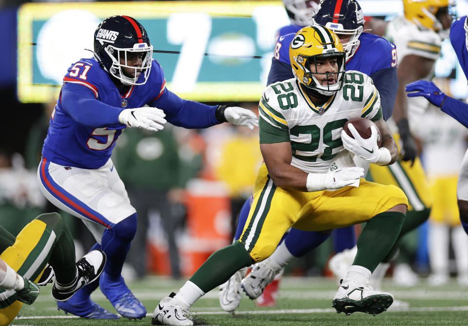 Green Bay Packers running back AJ Dillon (28) carries the ball against New York Giants linebacker Azeez Ojulari (51) during the second quarter of an NFL football game, Monday, Dec. 11, 2023, in East Rutherford, N.J. (AP Photo/Adam Hunger)