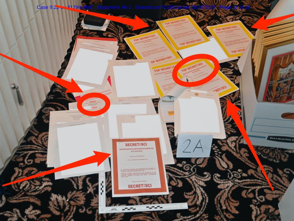 Photo of documents seized by FBI at Mar-a-Lago strewn across the floor, with red circles and arrows pointing to the ones with classification markings.
