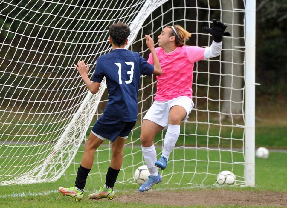 Rockland's Gabriel DaSilva, left, gets his shot past East Bridgewater goal keeper Anthony Patete, right, during boys soccer at Rockland High School, Monday, Oct. 3, 2022.