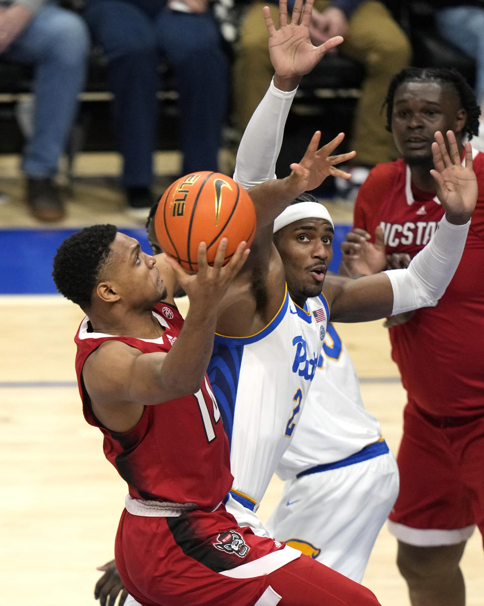 North Carolina State's Casey Morsell, left, is fouled by Pittsburgh's Blake Hinson (2) during the first half of an NCAA college basketball game in Pittsburgh on Saturday, March 9, 2024. (AP Photo/Gene J. Puskar)