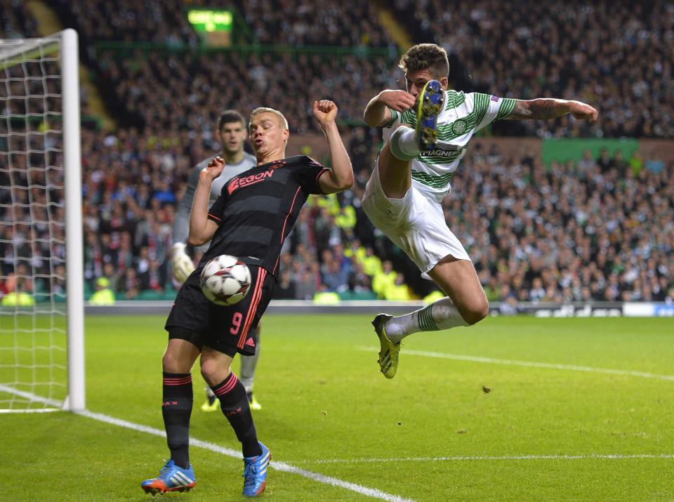 Celtic's Charlie Mulgrew (R) challenges Ajax's Kolbeinn Sigthorsson during their Champions League soccer match at Celtic Park Stadium, Scotland October 22, 2013. REUTERS/Russell Cheyne (BRITAIN - Tags: SPORT SOCCER)