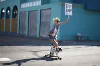 Kristen Schonert skateboards past a Snap Inc. office with a protest sign in Venice, a beach community of Los Angeles, California, U.S., March 2, 2017. REUTERS/Lucy Nicholson