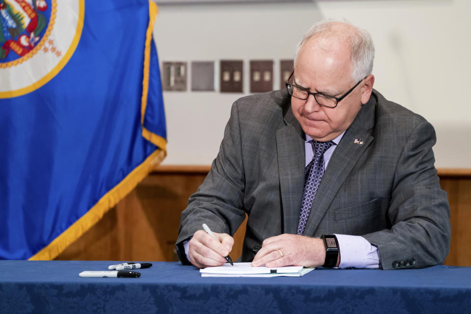 FILE - Gov. Tim Walz signs into law a sweeping package of police accountability measures in St. Paul, Minn., on July 23, 2020, including a ban on neck restraints, in the wake of George Floyd's death. (Glen Stubbe/Star Tribune via AP, File)