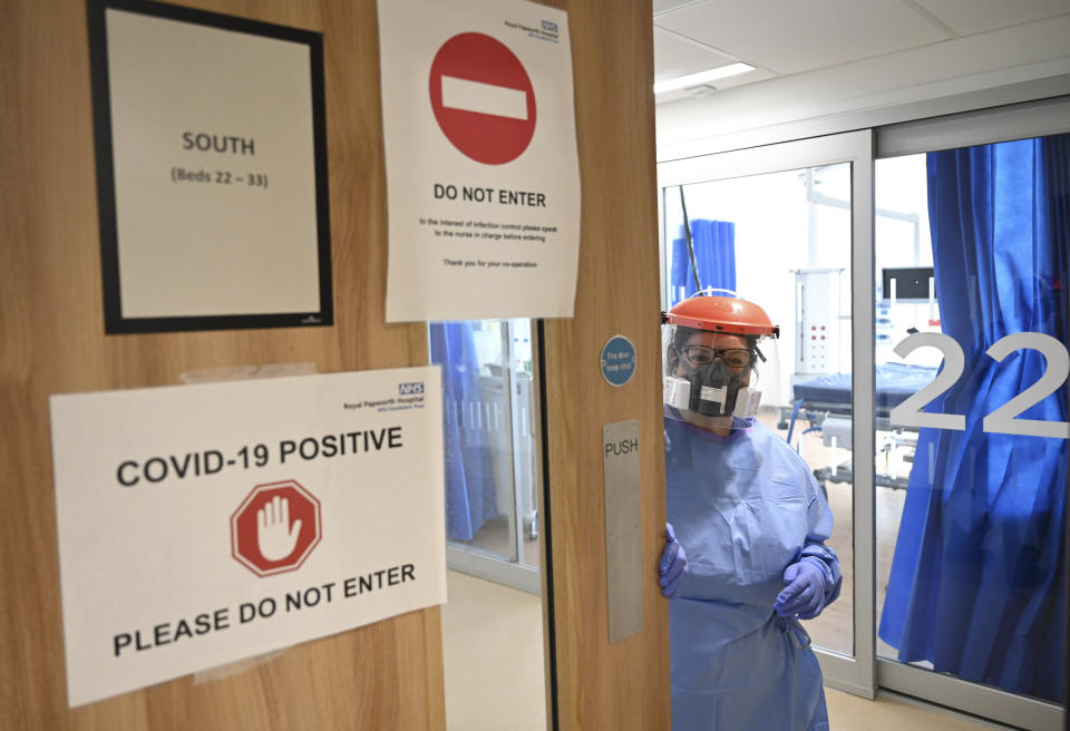 Members of the clinical staff wearing Personal Protective Equipment PPE care for a patient with coronavirus in the intensive care unit at the Royal Papworth Hospital in Cambridge, England, Tuesday May 5, 2020. (Neil Hall/Pool via AP)